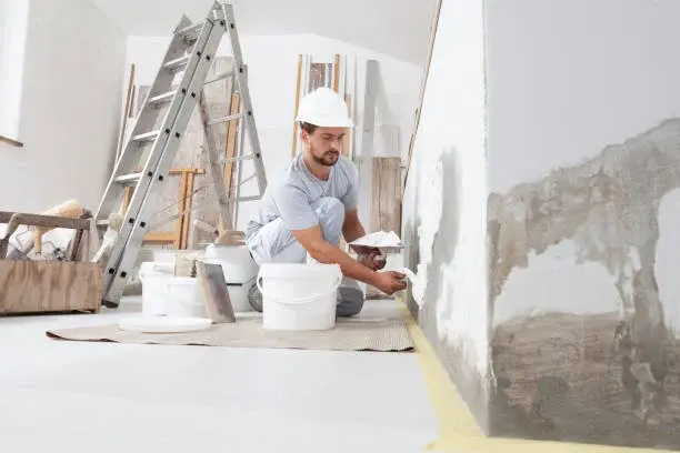 handyman painting wall with brush
